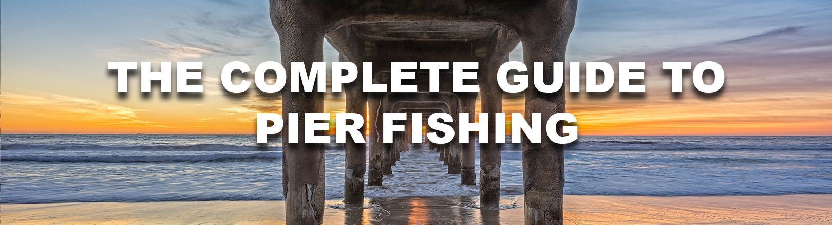 Text reads “THE COMPLETE GUIDE TO PIER FISHING.” Background shows a sunset view from beneath a pier with ocean waves and wet sand reflecting the sky.