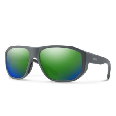 Smith Outrigger Sunglasses, front 3/4 view, matte black frame with green to blue mirror lenses, wraparound shape with molded nose pads and curved arms, "SMITH" white text on temple  