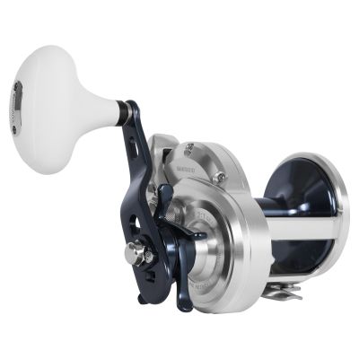 
Shimano Trinidad A TN30A Conventional Reel &ndash; Angled view of silver-colored reel frame with navy spool, navy handle arm, and large white knob; SHIMANO branding and 6.2:1 gear ratio marking visible on side plate.
