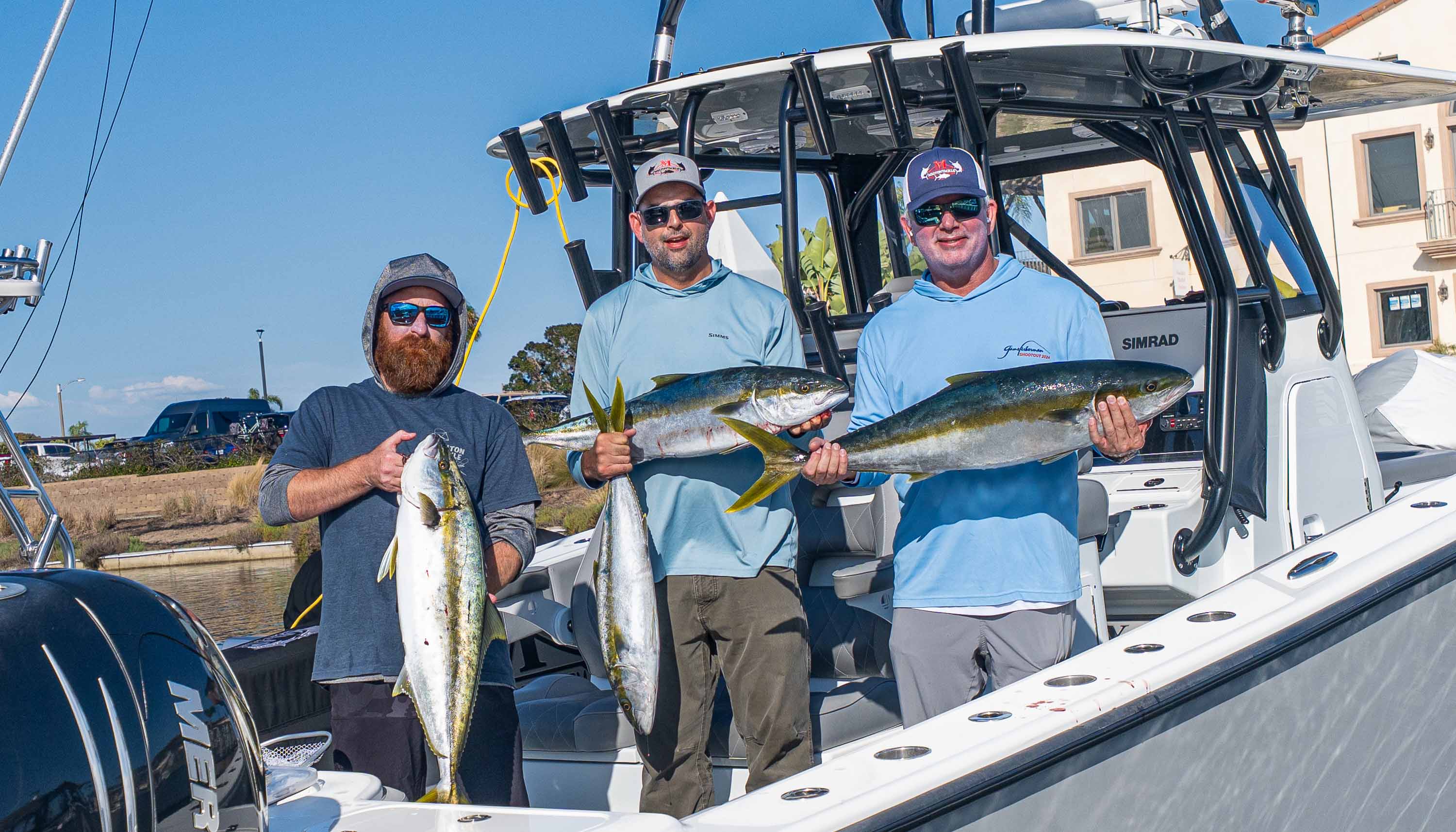 Wintertime Yellowtail on Artificials - Melton team members holding yellowtail catches aboard a fishing boat.